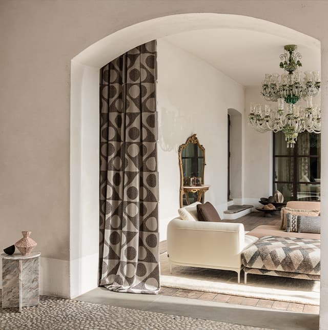 Ein gemusterter Vorhang und ein weißes Sofa im Wohnzimmer.