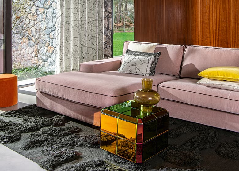 Ein rosa Sofa bezogen mit einem schwerentflammbaren Stoff.