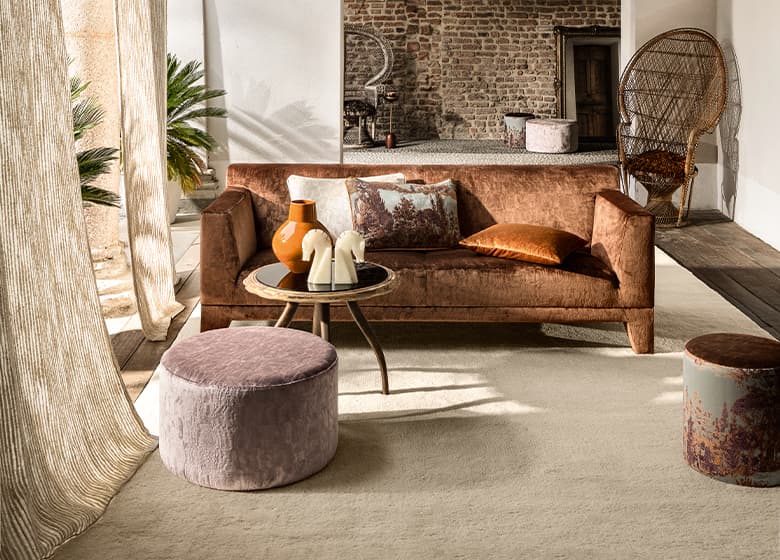 Eine orangene Couch und ein beiger Teppich im Wohnzimmer.