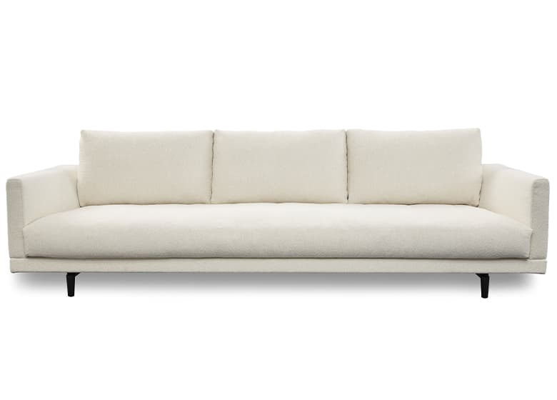 Freisteller eines weißen Sofas mit einer durchgängigen Sitzfläche und drei Rückenkissen.