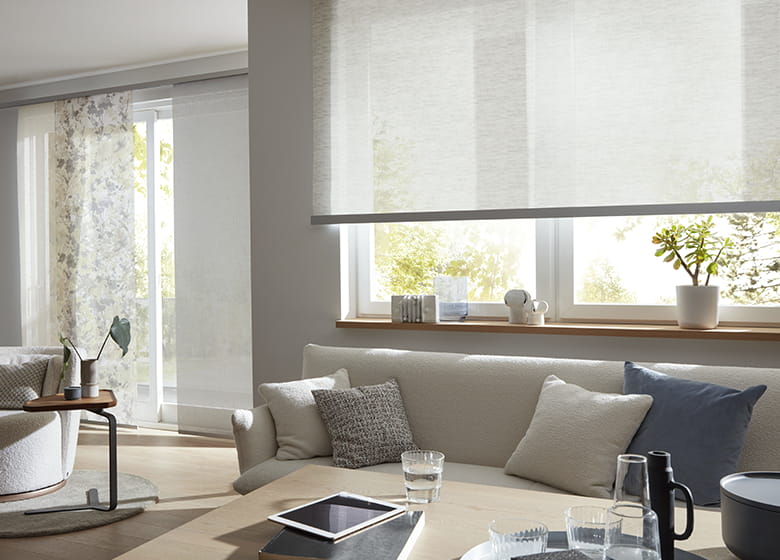 Helles Wohnzimmer mit floralem Rollo am Fenster