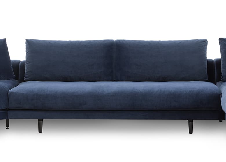 Frontalaufnahme eines blauen Sofas mit einem Rückenkissen und einer großen SItzfläche.