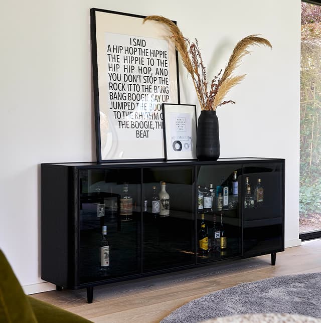 Sideboard Allure vor einer weißen Wand mit Bildern auf dem Sideboard