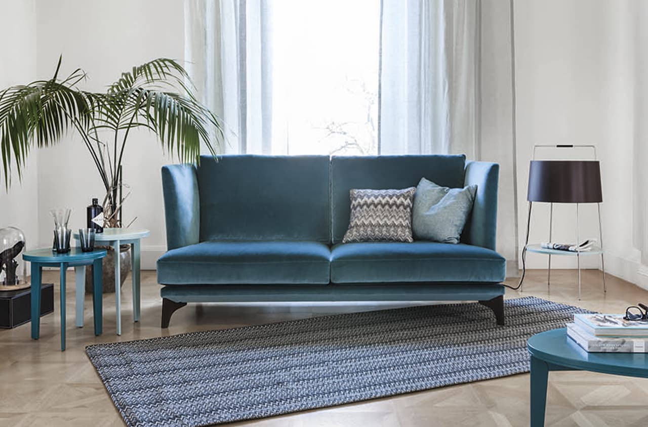 Blaues Sofa in einem hellen Rum mit blauen Akzenten