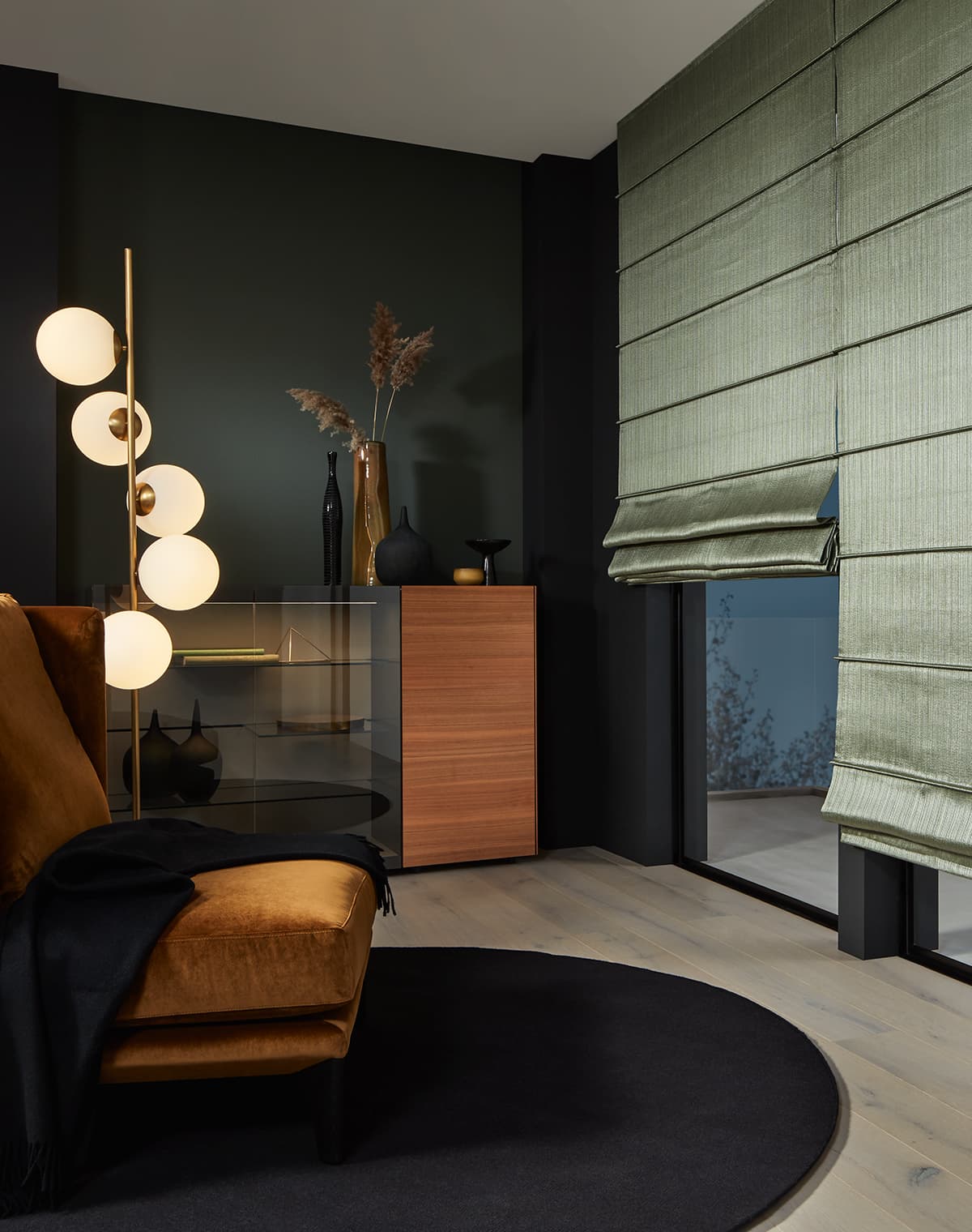 Modernes Wohnzimmer mit smaragdgrünen, metallischen Faltrollos und nachtblauem Teppich.