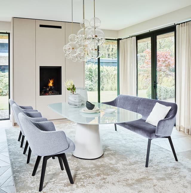 Essbereich mit grauen Esszimmerstühlen und dazugehöriger Diningbank.