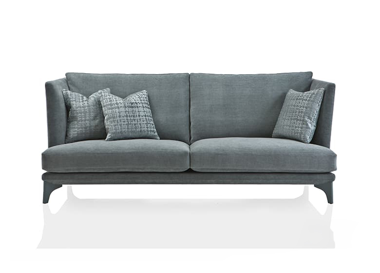 Freisteller eines grau/blauen Sofas mit drei Deko-Kissen und zwei Sitzflächen.