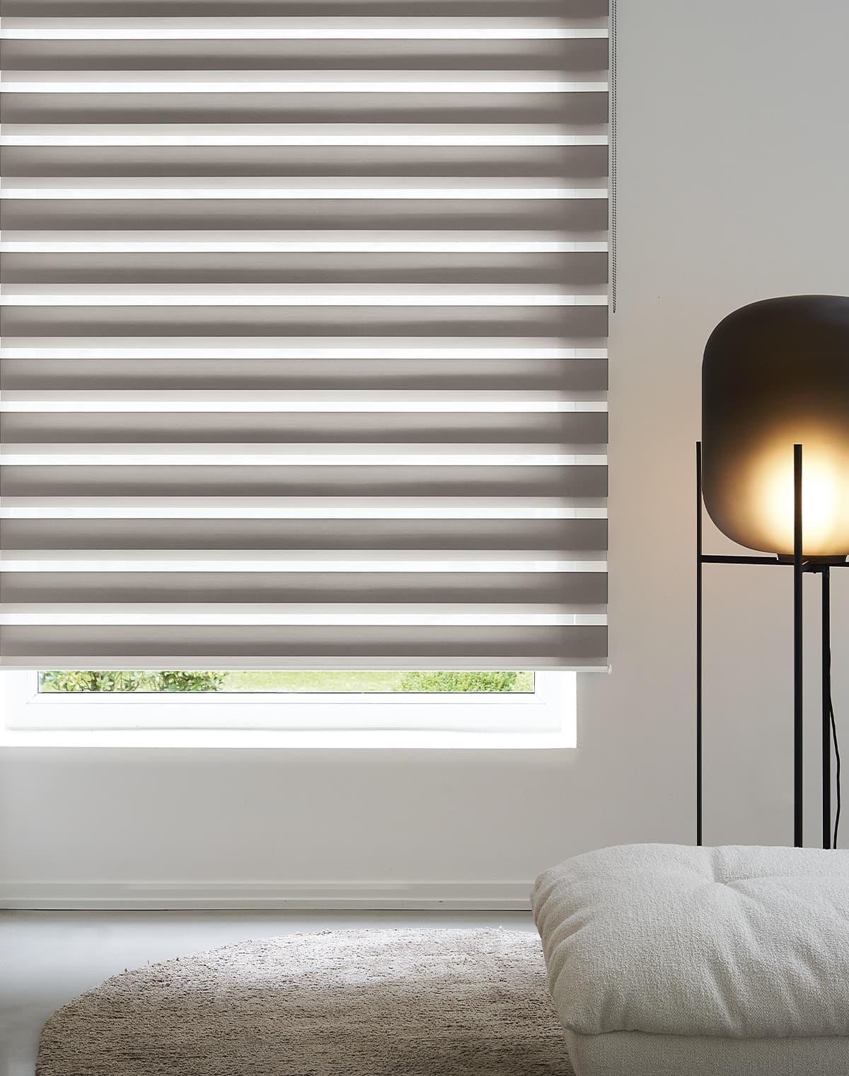 Gemütliche Sitzecke in neutrals mit einem hell gestreiftem Doppelrollo am Fenster
