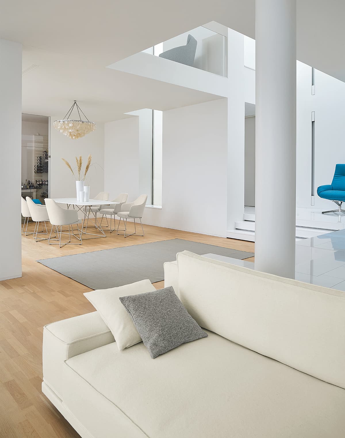 Angeschnittenes weißes Sofa, im Hintergrund ist eine weiße Essgruppe