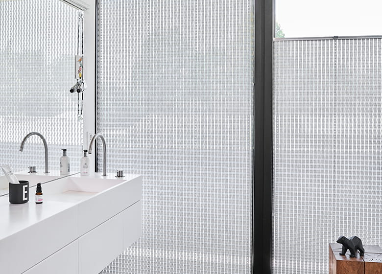 Badezimmer mit großen Fenstern und weißen Plissees