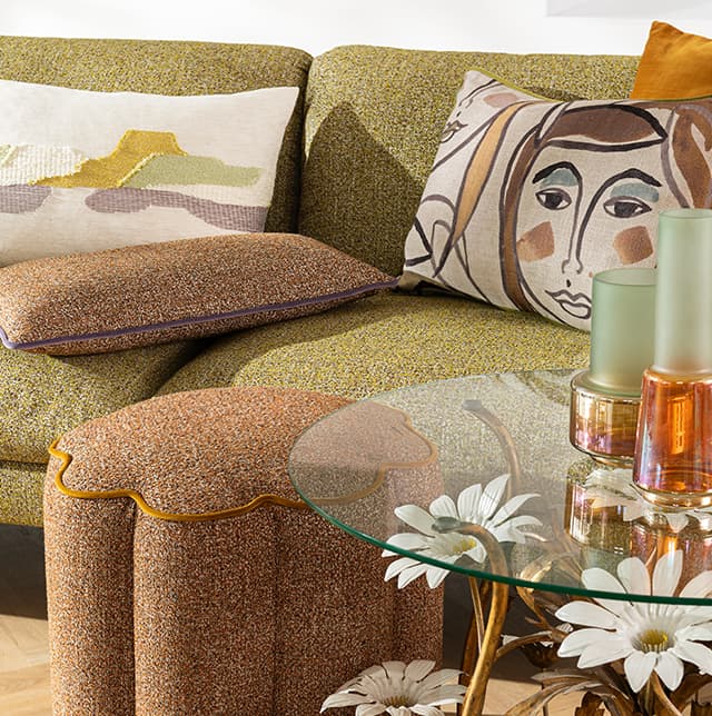 Kissen mit Gesichtprint auf grüner Couch