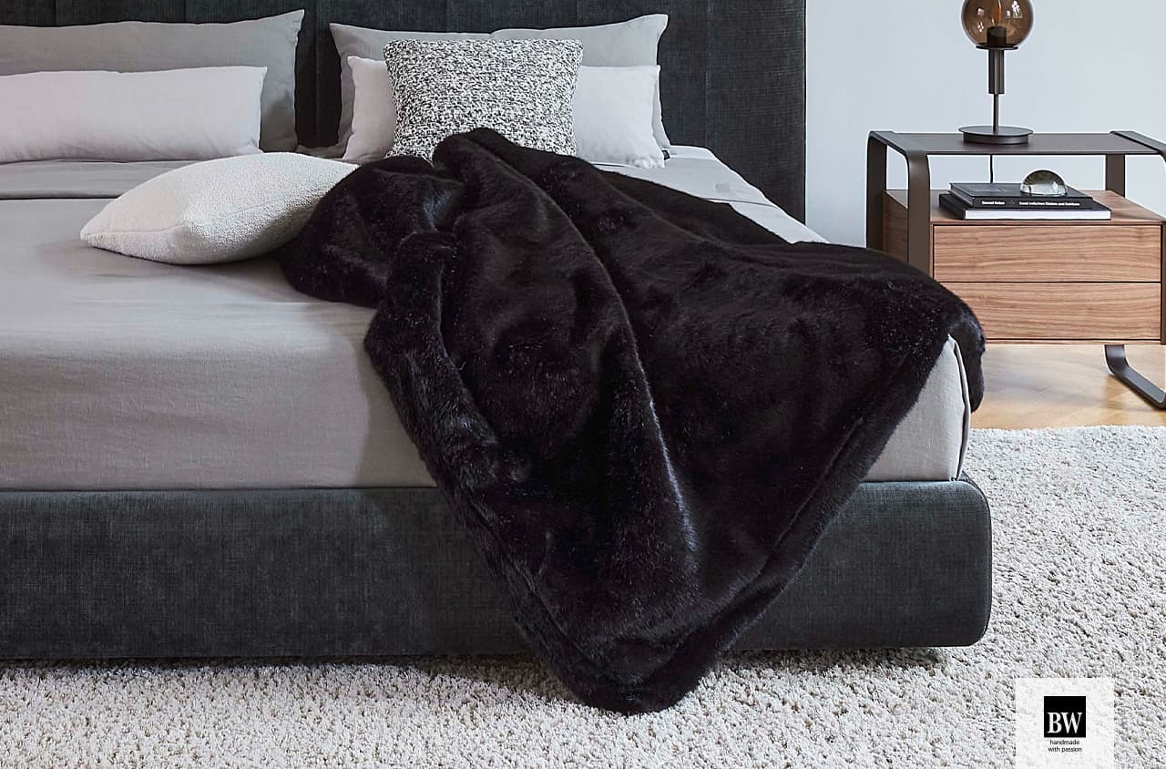 Plaid Soft Whisper in schwarz auf einem Bett